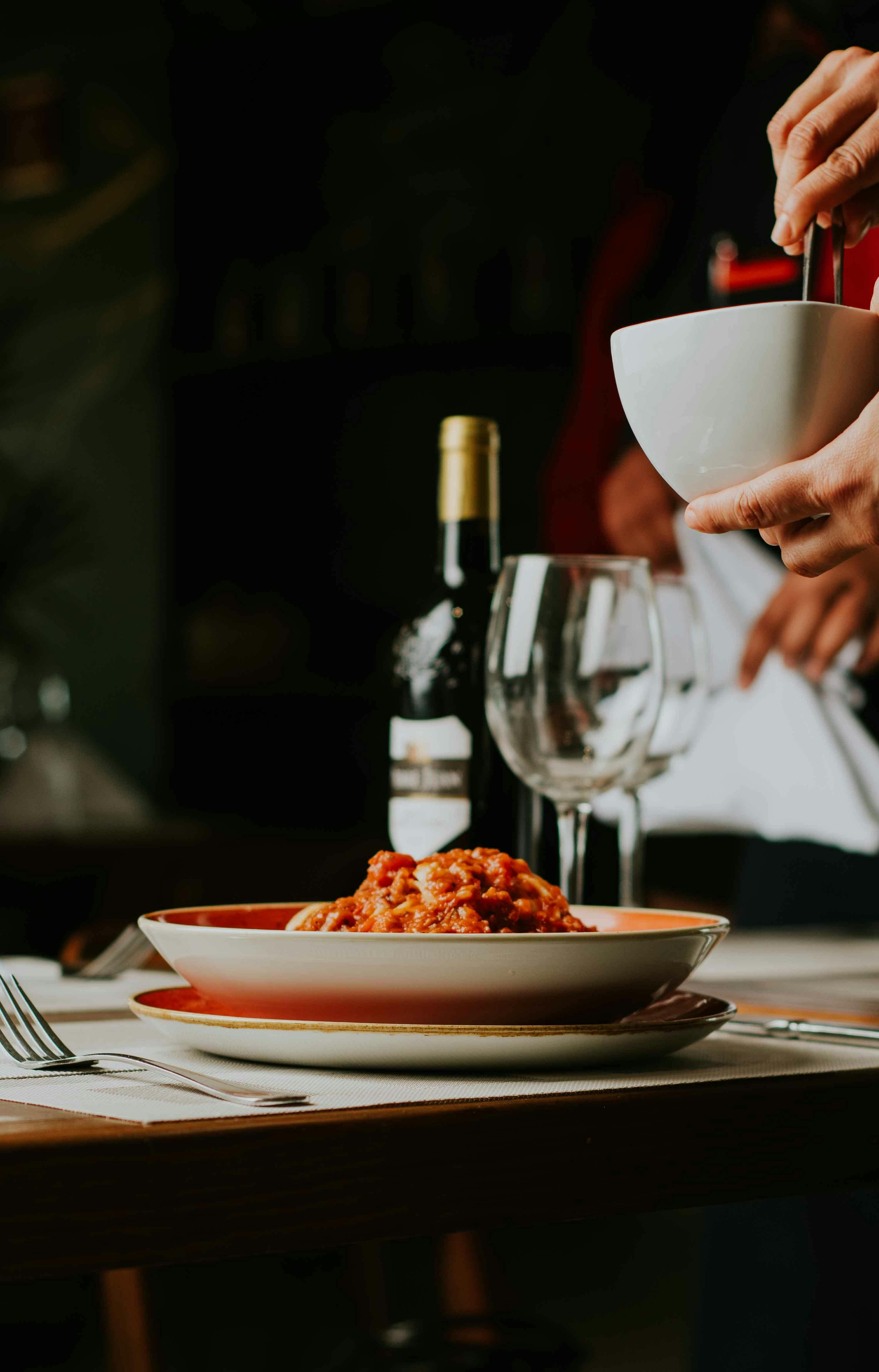 Italian dinner hosting with pasta dish, wine glasses, and cozy table setting for an authentic Italian evening