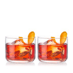 Two glasses of red cocktail with orange slices on a white background
