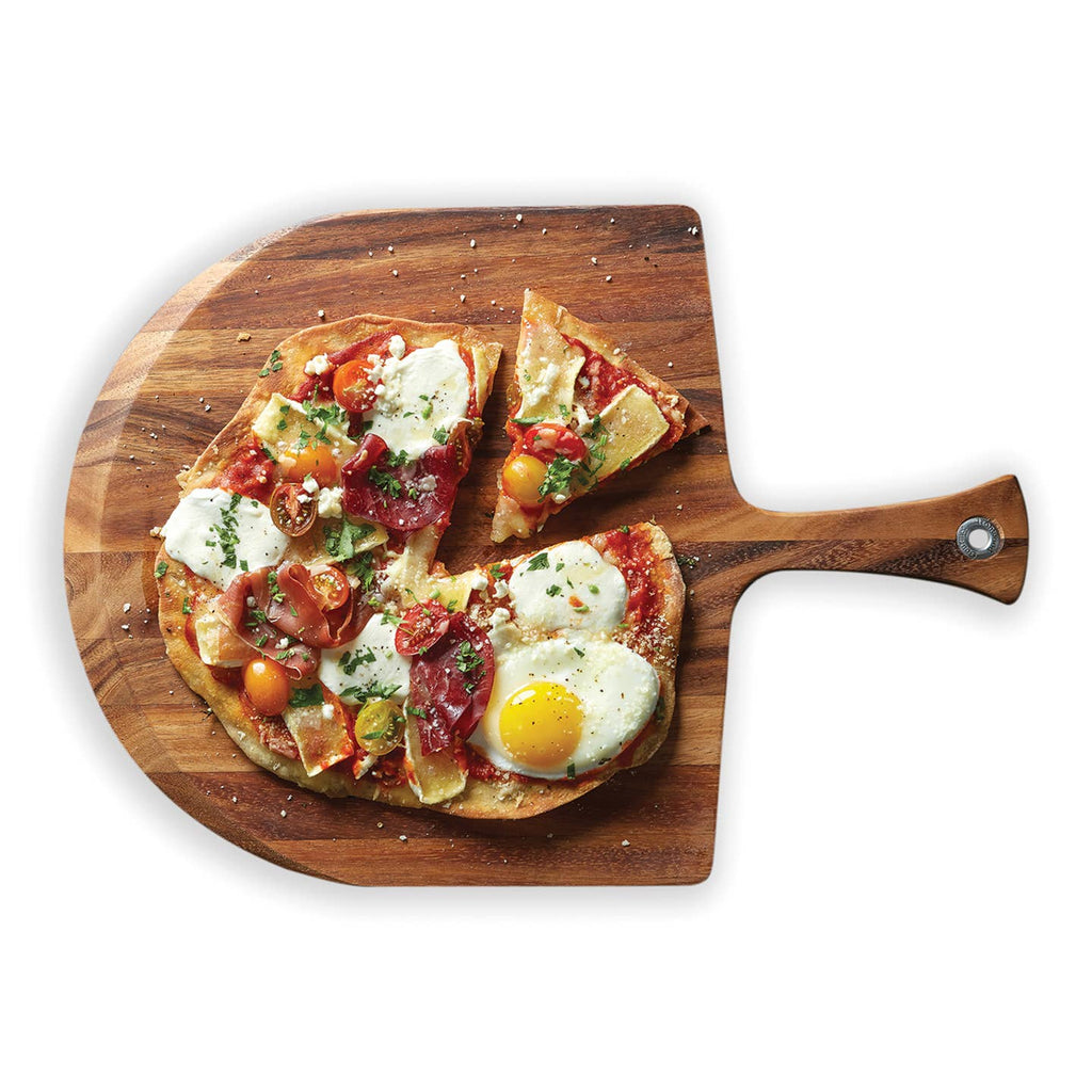 A wooden pizza peel holding a partially eaten pizza topped with tomatoes, cheese, greens, and a sunny-side-up egg, photographed on a clean white background.